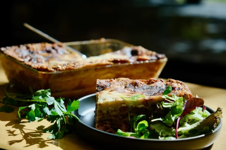 Part de lasagnes maison servie avec une salade verte